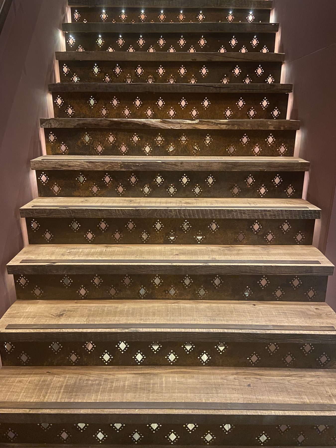 Verlichte trap met houten treden en decoratieve stootborden